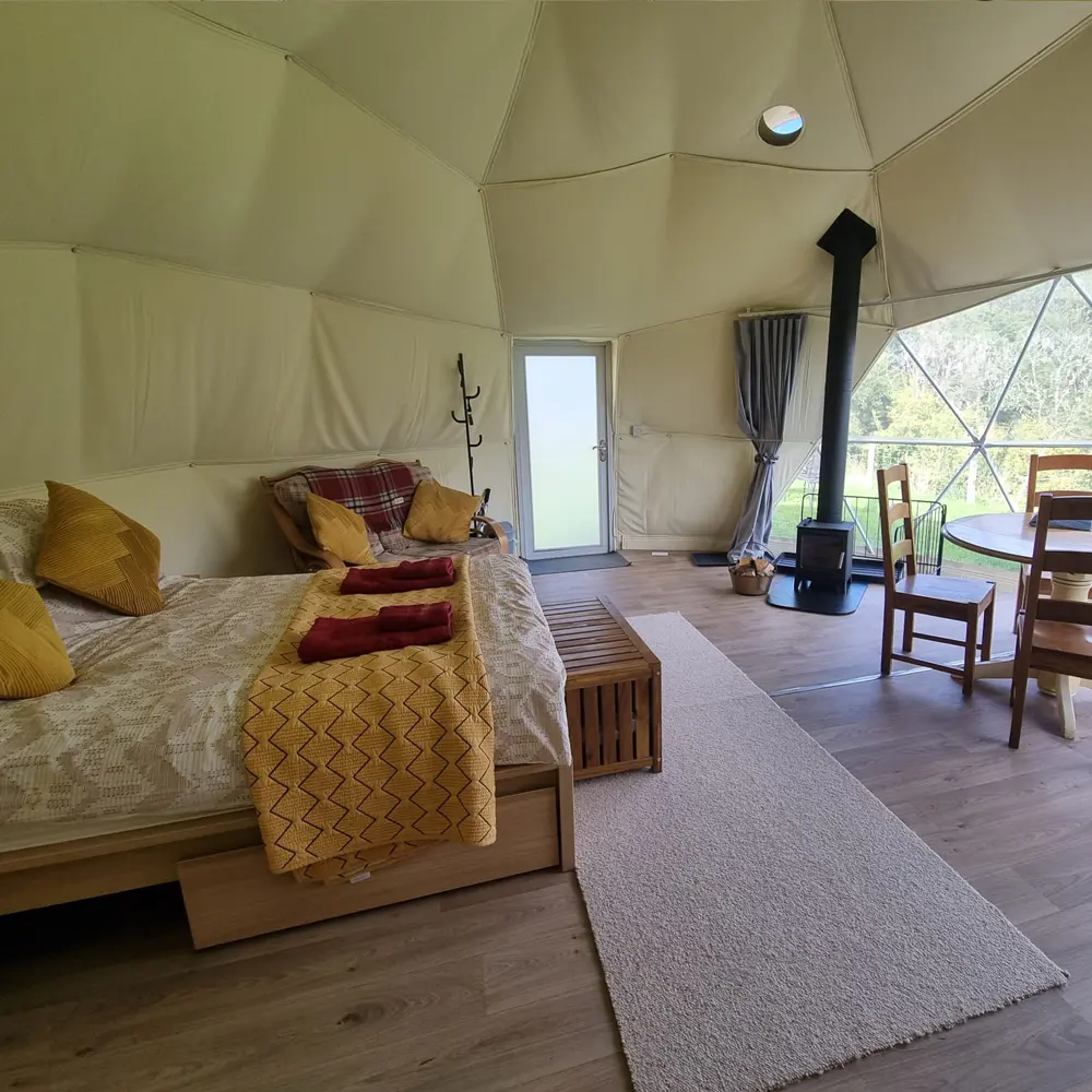 Eira Dome inside with log burner Inside Eira Geodome with log burner